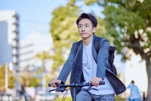 Young,Japanese,Man,In,A,Jacket,Riding,A,Bicycle