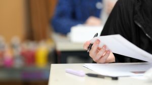 A,Close,Up,Isolated,Students,Hand,Holding,A,Pen,Checking