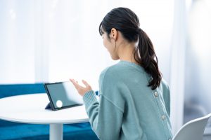 Young,Japanese,Woman,Speaking,At,A,Computer